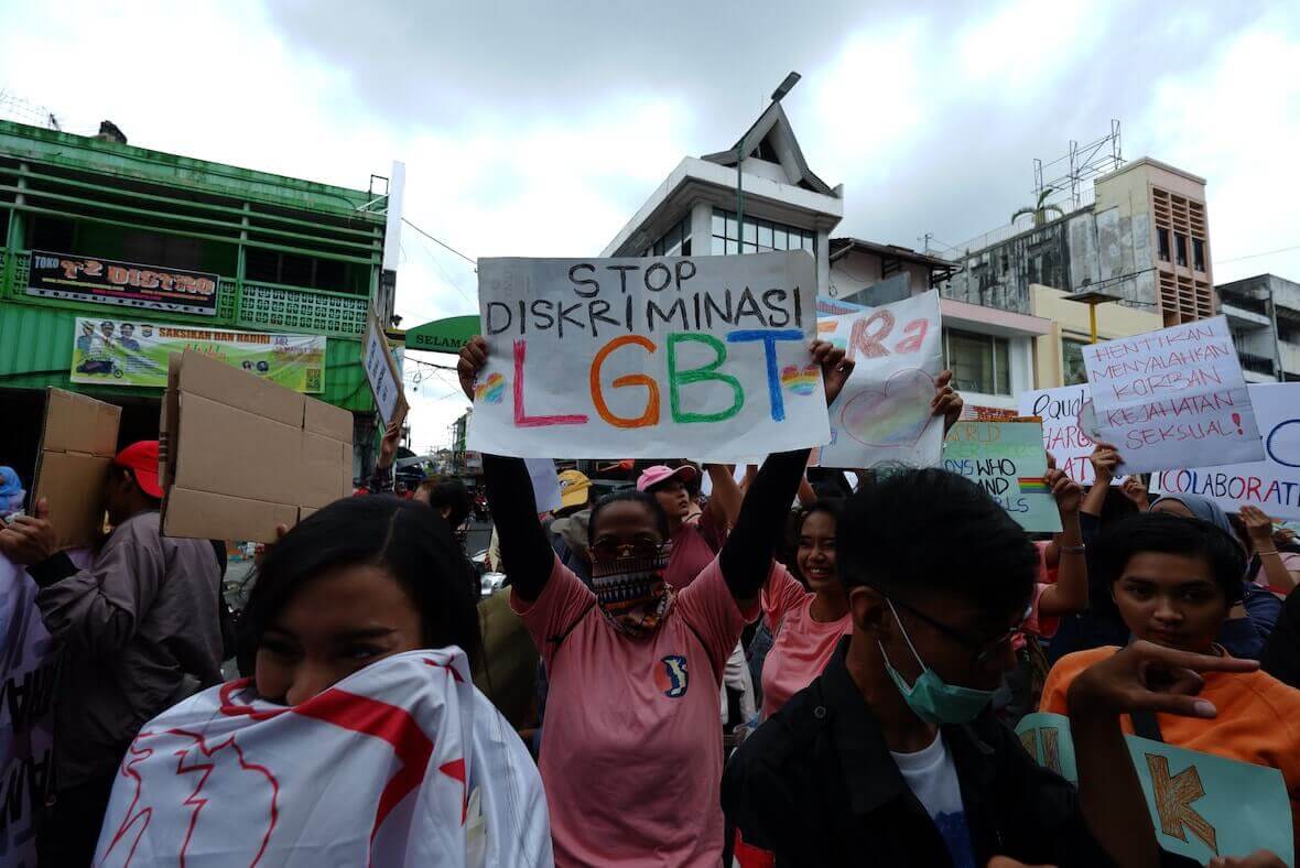 Un manifestante regge un cartello che chiede la fine della discriminazione LGBT come parte della Marcia delle donne del 2023.
