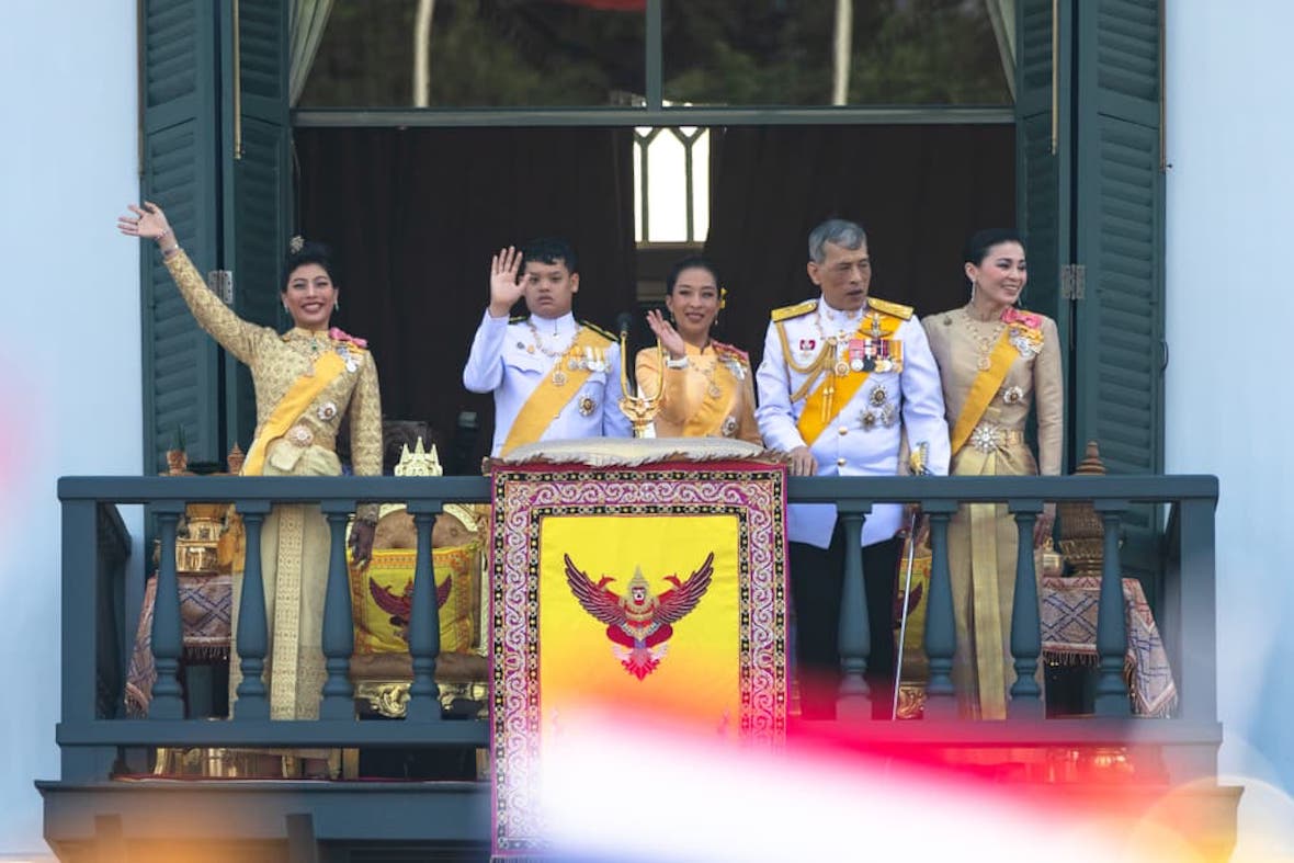 شوهد الملك التايلاندي مها فاجيرونجكورن والملكة سوثيدا والأمراء والأمراء في شرفة القصر الكبير وهم يحيون الجمهور.