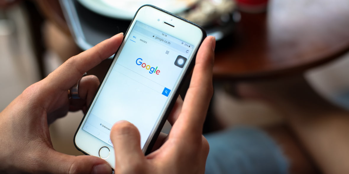 Persoană care utilizează motorul de căutare Google pe un iPhone