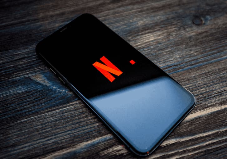 foto telefon di atas meja memuatkan Netflix